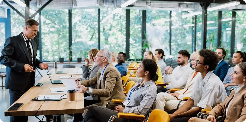 Industry consortiums image showing business professionals in formal attire in a meeting room engaged in strategic conversation.
