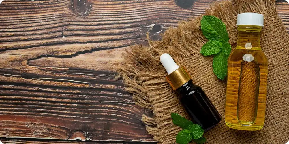 A photo of multiple glass bottles containing essential oil blends, with droplets and fresh botanicals like lavender or eucalyptus.