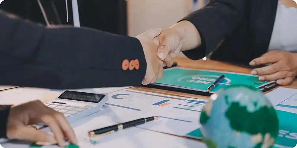 Image of two hands shaking, symbolizing fair trade compliance and ethical partnership.