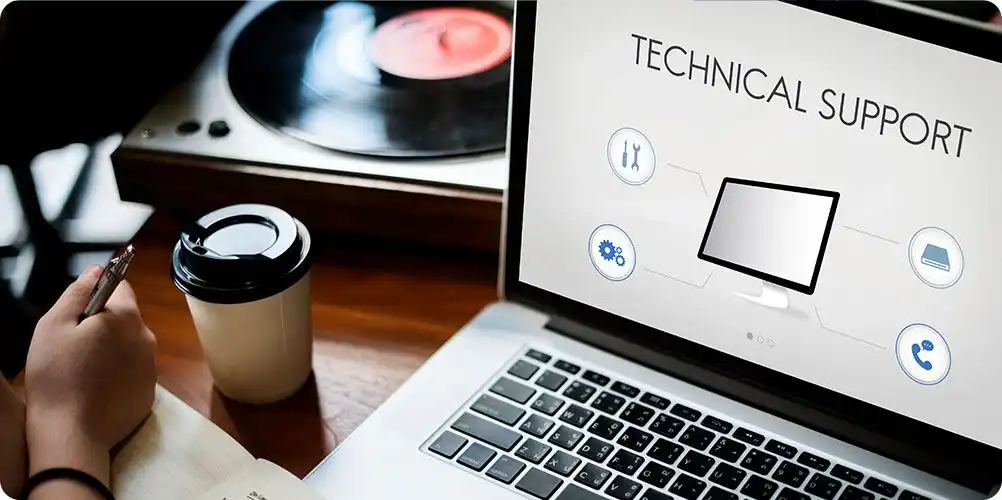 Technical support image showing a professional man in a headset assisting customers with computer equipment in the background.