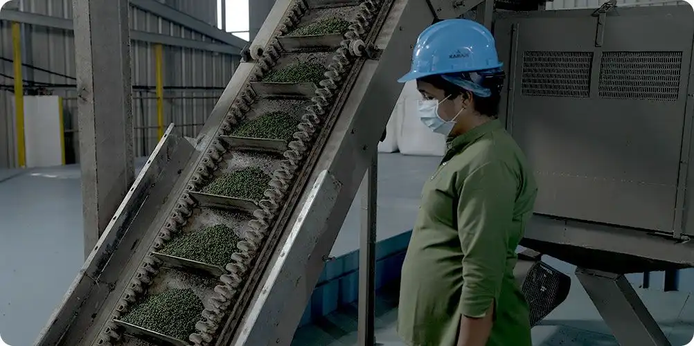 Green processing technologies banner featuring modern green-colored industrial infrastructure surrounded by trees, emphasizing eco-friendly manufacturing.