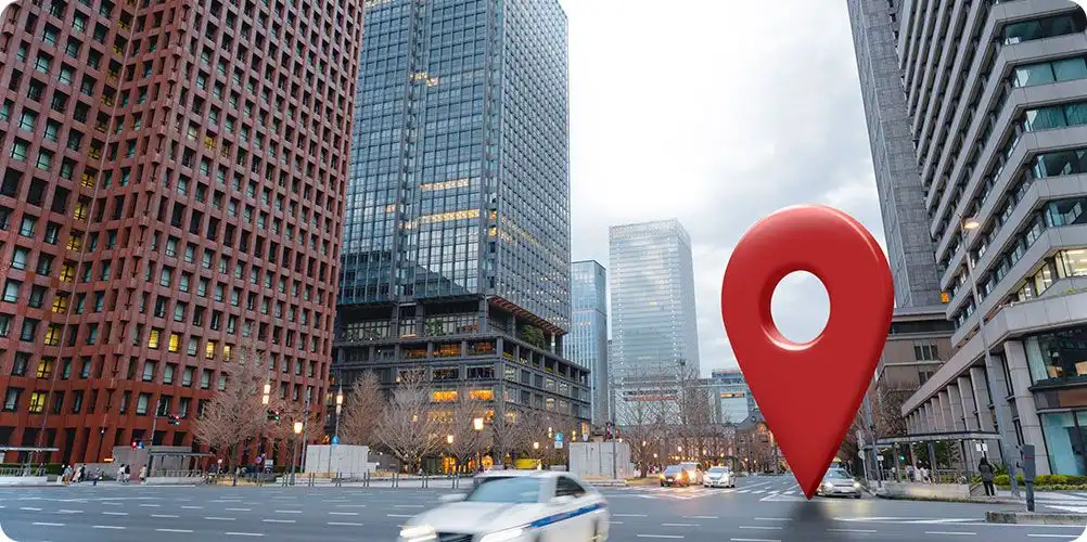 Large red map location pin marker superimposed over a busy intersection in a major city center.