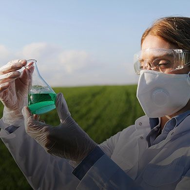 Woman dressed in medical attire holding a clear substance, similar to image two, emphasizing healthcare or scientific roles.